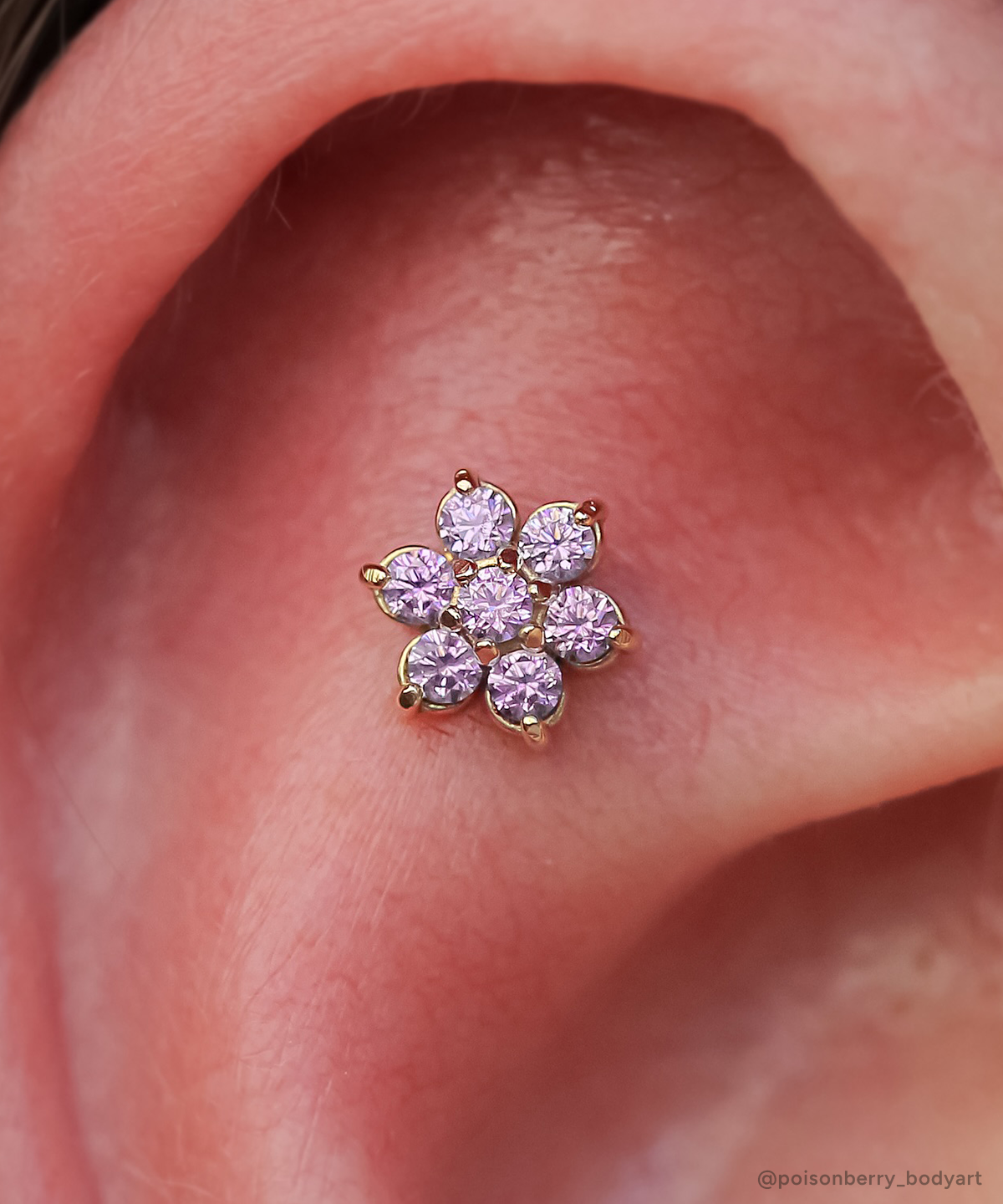 Yellow gold Flower end with Amethyst gemstones in a flat helix piercing.